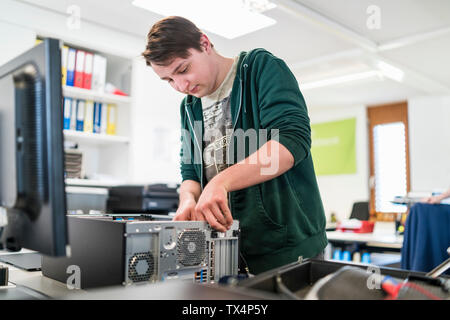 Teenager assembling personal computer Stock Photo