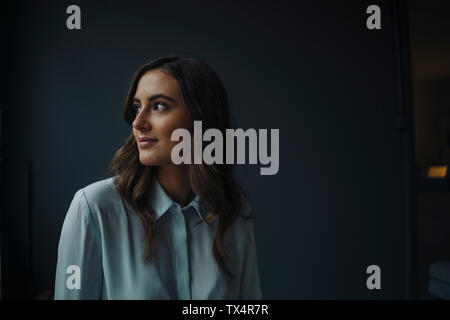 Portrait of smiling young businesswoman looking sideways Stock Photo