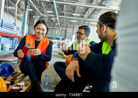 Workers in factory having lunch break together Stock Photo