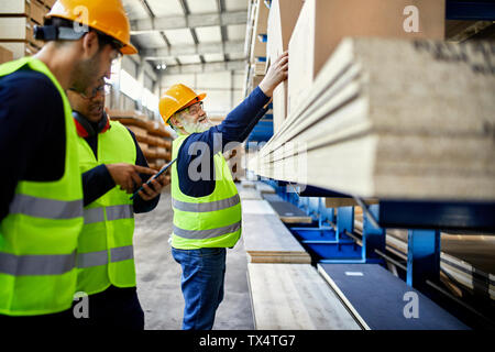 Workers talking in factory warehouse Stock Photo