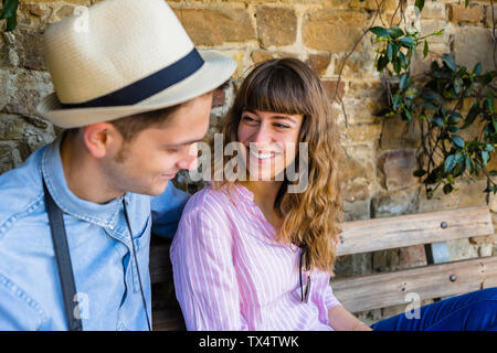 Young couple on a city break, sitting on a bench, taking a break Stock Photo
