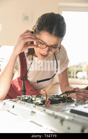 Young woman working on computer equipment at home Stock Photo