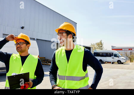 Two workers talking on factory yard Stock Photo