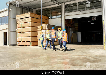 Group of workers walking on factory yard Stock Photo