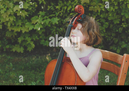 A girl taking a break during her cello exercises Stock Photo