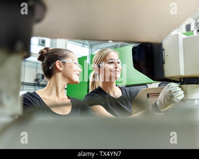 Two women working on a machine Stock Photo