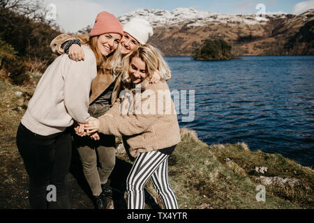 UK, Scotland, happy female friends hugging at Loch Lomond Stock Photo