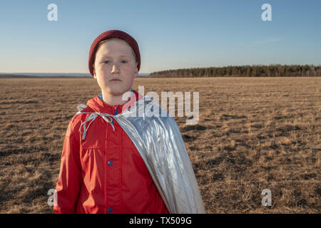 Portrait of boy dressed up as superhero in steppe landscape Stock Photo