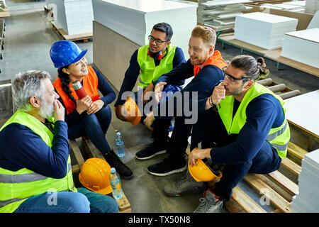 Workers in factory having lunch break together Stock Photo