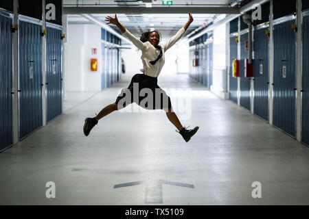 Woman jumping in car park Stock Photo