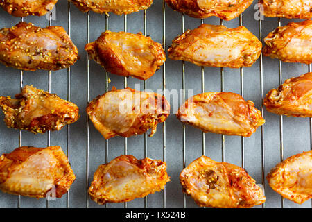 Preparing of spicy chicken wings, grid Stock Photo