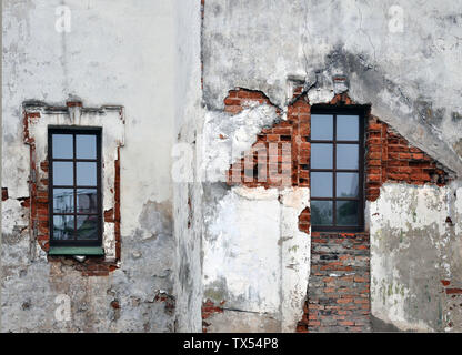 Empty old brick wall texture with windows. Painted problematic surface of the wall. Grungy Wide Brickwall. Grunge Red Stone Background. Shabby buildin Stock Photo