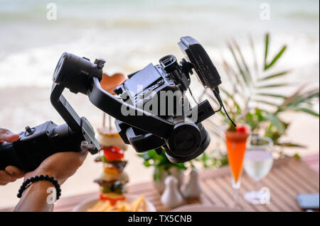 Professional working with mirrorless camera and mic wireless on gimbal stabilizer for filming Stock Photo