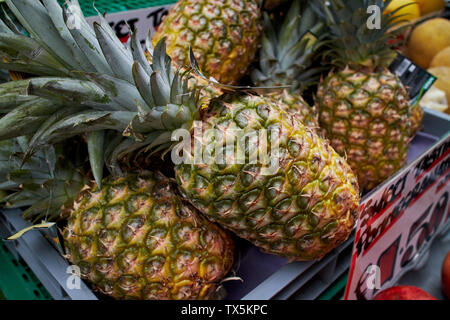 Juicy, fresh, vivid pineapples on sale at a market. Stock Photo
