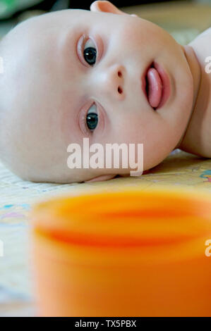 A 6 month old child with Down Syndrome looking at a therapy toy Stock Photo