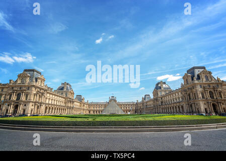 Symmetric view of the main courtyard of the Louvre palace with the historical buildings and the modern pyramid, Paris france Stock Photo