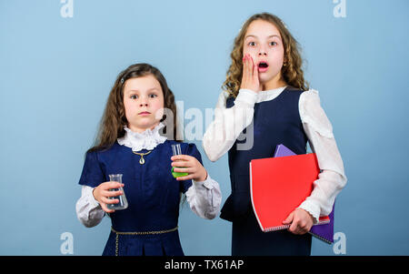 shocked about results. little smart girls with testing flask. biology education. children study chemistry lab. school kid scientist studying science. back to school. girls with folder. feel shocked. Stock Photo