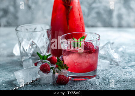 Raspberry cocktail, fizz, lemonade, ice tea with fresh mint on blue wooden background. Close up. Stock Photo