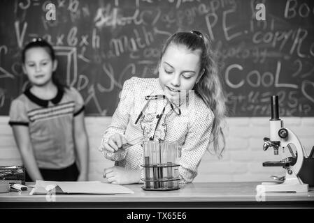 Girls working chemical experiment. Natural science. Educational experiment. School classes. Biology and chemistry lessons. Observe chemical reactions. Chemical reaction much more exciting than theory. Stock Photo