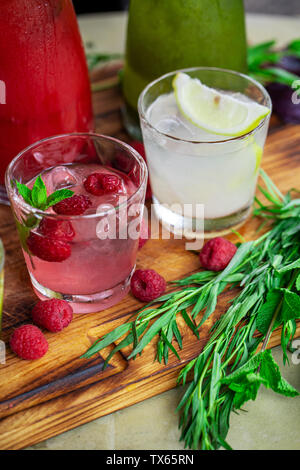 Summer soft drinks, a set of lemonades. Lemonades in jugs on the table, the ingredients of which they are made are arranged around. Stock Photo