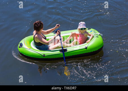 Woman and young girl having fun in inflatable dinghy on Dorset Dinghy Day at Iford going along River Stour to Tuckton, Dorset UK in June Stock Photo
