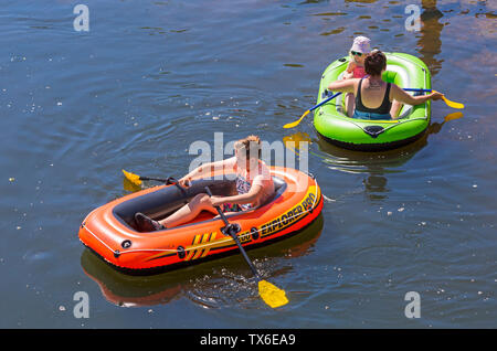 having fun in inflatable dinghies on Dorset Dinghy Day at Iford going along River Stour to Tuckton, Dorset UK in June Stock Photo