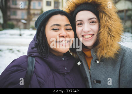 portrait of two young women smiling and looking camera – multiracial, friendship, cheerful Stock Photo