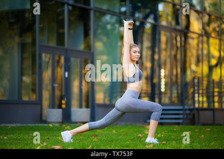 Healthy lifestyle. Fitness woman doing exercise in city environment Stock Photo