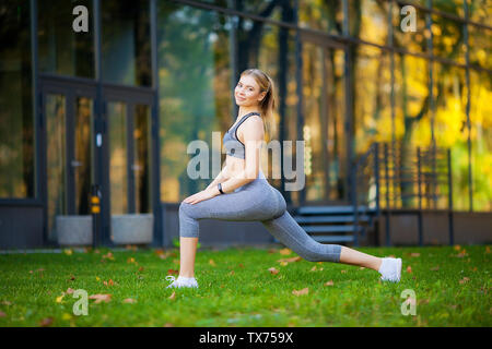 Healthy lifestyle. Fitness woman doing exercise in city environment Stock Photo