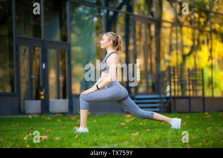Healthy lifestyle. Fitness woman doing exercise in city environment Stock Photo