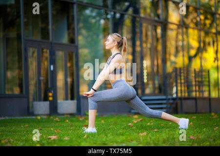 Healthy lifestyle. Fitness woman doing exercise in city environment Stock Photo