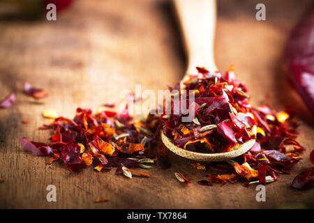 Spicy Chili paste mix with peppers on wooden background. This condiment could be ingredient of harissa, ajika, muhammara or other middle east food. Cl Stock Photo