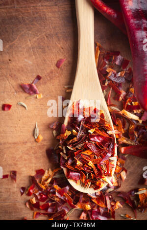 Spicy Chili paste mix with peppers on wooden background. This condiment could be ingredient of harissa, ajika, muhammara or other middle east food Stock Photo
