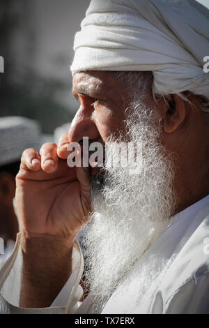 NIZWA, OMAN - APRIL 4, 2011: Elderly man with long white beard wearing the national male dress of Oman. Stock Photo