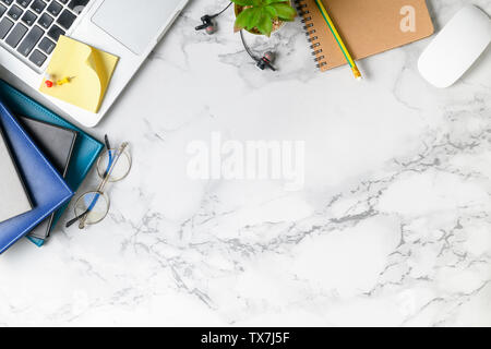 Modern marble desk table with laptop, other supplies with copy space for input the text. Top view, flat lay. Stock Photo