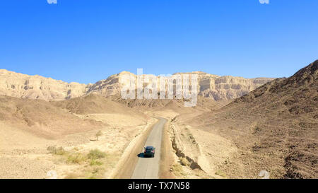 Single car on an old Desert road, Aerial follow image. Stock Photo