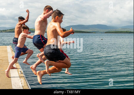 Bantry, West Cork, Ireland. 24th June, 2019. A group of boys jump into the water in Bantry Bay to cool off on a very warm and humid day in West Cork with temperatures reaching 23°C. Met Eireann has issued a yellow thunderstorm weather warning, which is in place until 10pm tonight. Credit: Andy Gibson/Alamy Live News. Stock Photo