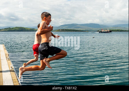 Bantry, West Cork, Ireland. 24th June, 2019. A group of boys jump into the water in Bantry Bay to cool off on a very warm and humid day in West Cork with temperatures reaching 23°C. Met Eireann has issued a yellow thunderstorm weather warning, which is in place until 10pm tonight. Credit: Andy Gibson/Alamy Live News. Stock Photo