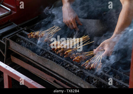 Chicken satay grill at a busy street food market Stock Photo