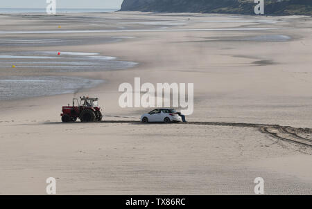 Car stranded on sandy beach at Wissant in northern France being towed by tractor Stock Photo