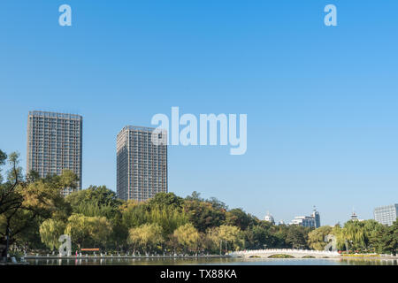 Autumn China Fushun early morning park river bank willow stone bridge cruise ship Stock Photo