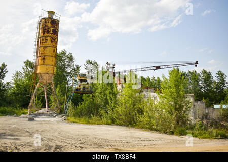 Fallen rusty industry concept photo in the abandoned cement factory with aged grunge concrete and metal strucures. Stock Photo