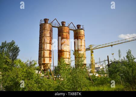 Fallen rusty industry concept photo in the abandoned cement factory with aged grunge concrete and metal strucures. Stock Photo