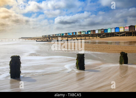 Groynes and beach huts ar Frinton-on-sea in Essex Stock Photo