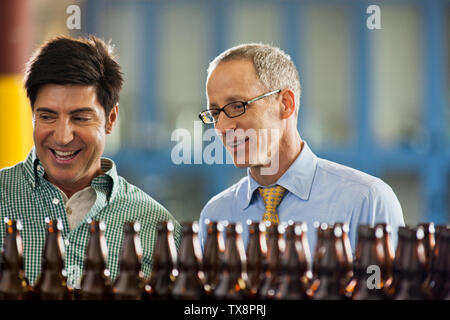Two colleagues discussing work in a brewery. Stock Photo