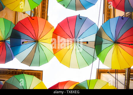 Multi-colored umbrellas background. Colorful umbrellas floating above the street. Street decoration. Stock Photo
