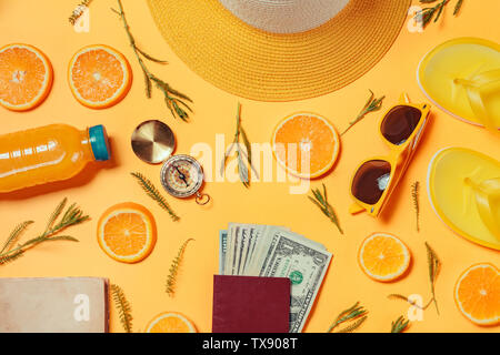 Money for travelling overseas. US dollars in passport with other summertime beach holiday accessories, top view flat lay Stock Photo