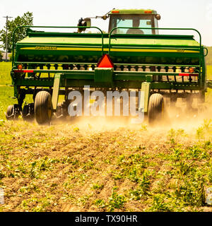 Farmer discing a spring crop field in springtime before planting. Stock Photo