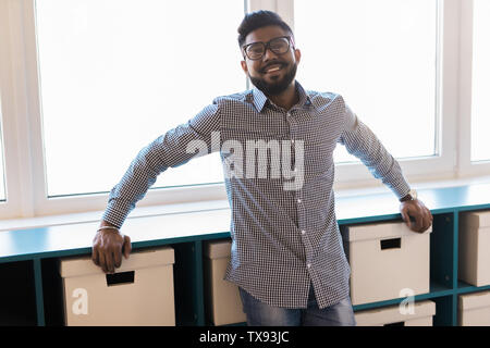Young man asian smiling and looking at camera. Portrait of happy handsome young man in office. Close up face of young cool trendy man looking at camer Stock Photo