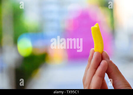 Candy bitten in hand, with a colorful background Stock Photo